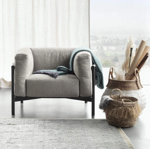 Poltrona imbottita con struttura in legno e morbidi cuscini Taiki di Lema